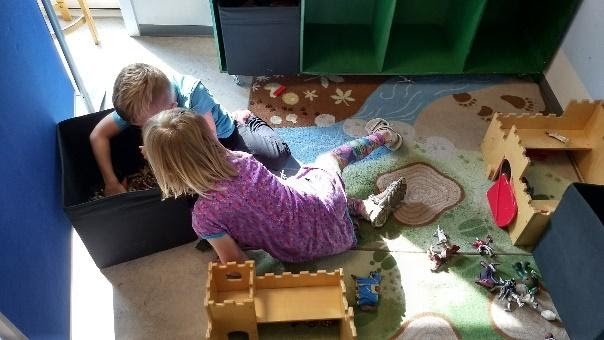 To børn kigger efter legetøj i en sort kasse